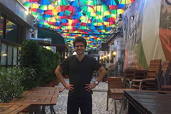 man with hands on hips with stained glass ceiling in the background