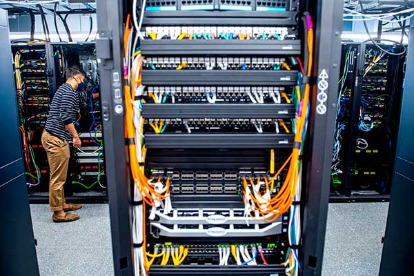 plugging network cables into the back of servers