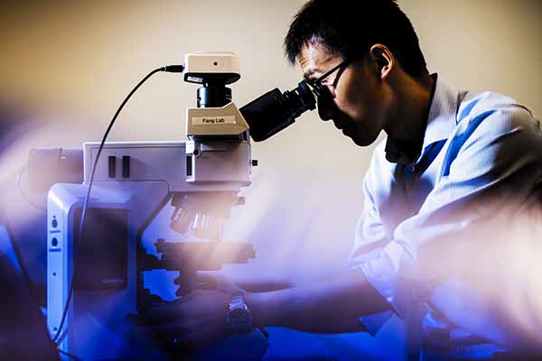 professor looking into microscope