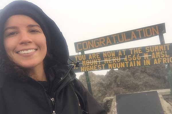 student on summit of mountain in africa