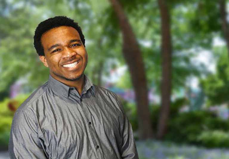 student sitting posing with blurred trees in the background